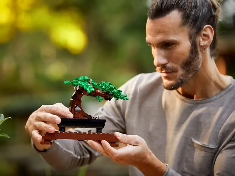 Man holding green bonsai.