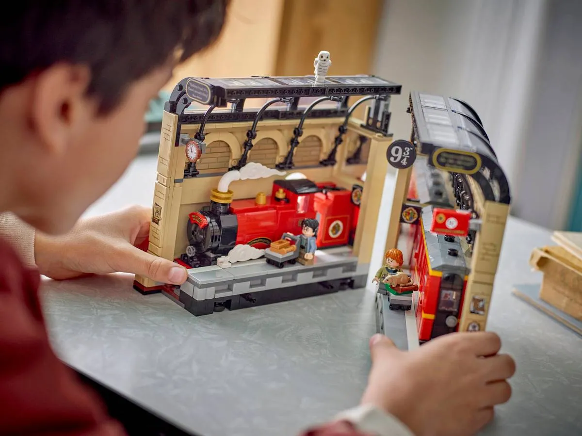 Hands joining the two LEGO set sections.