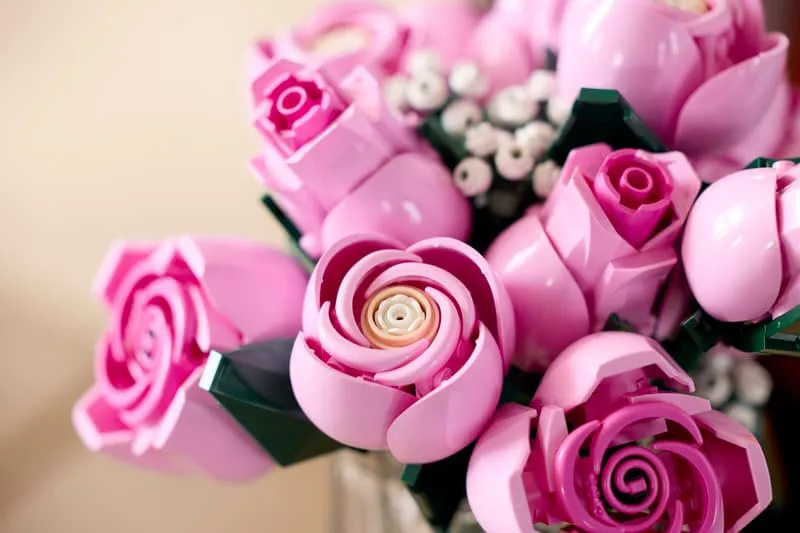 Extreme close-up of several LEGO pink roses, highlighting the intricate spiral centers and textured petals.