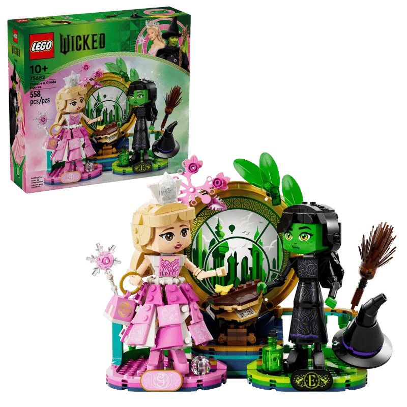 The assembled Lego Elphaba & Glinda figures standing on their display bases in front of the Emerald City backdrop, with the product box in the background.