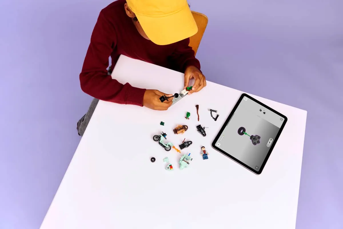 Child building LEGO with tablet instructions.