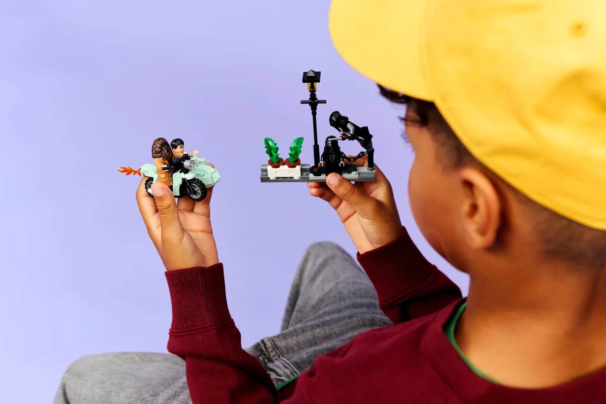 Child playing with LEGO motorcycle and streetlamp.