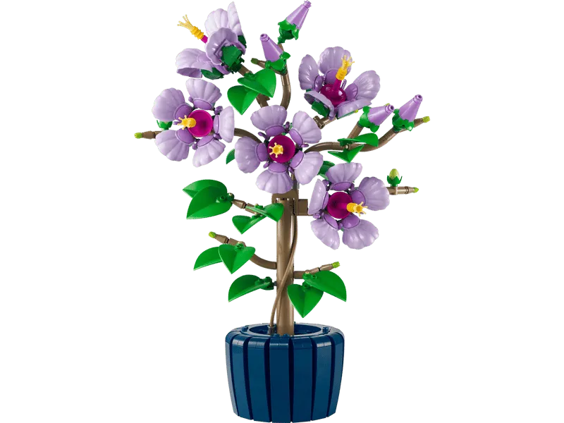 Finished Lego Hibiscus plant 10372 on a white background, showcasing light purple flowers, green leaves, and a dark blue pot.