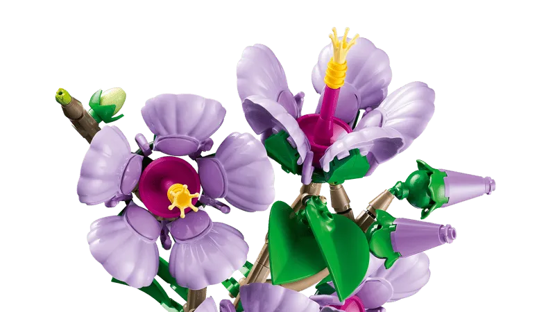 Close-up of Lego Hibiscus flowers and buds, showing the intricate details of the light purple petals, magenta centers, and yellow stamens, alongside green leaves.