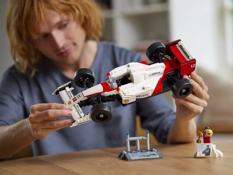 A person holding the completed Lego McLaren MP4/4 model, demonstrating its size and hands-on appeal.