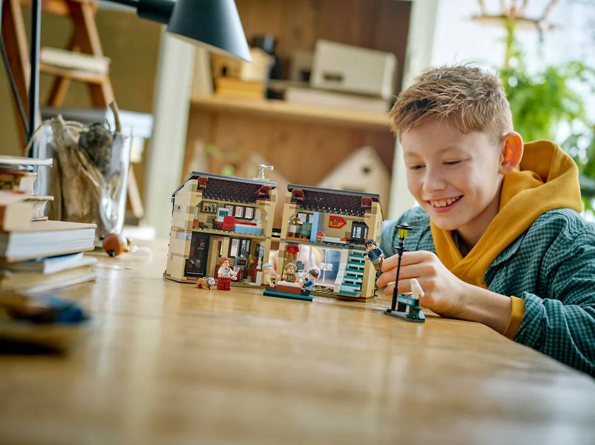 Child playing with closed LEGO Privet Drive.