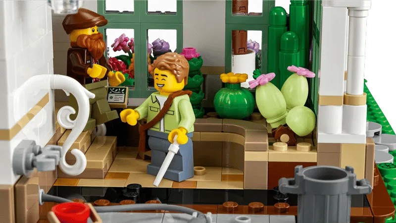 Close-up interior view of Lego The Botanical Garden 21353, showing minifigures interacting with plants and a potting area.